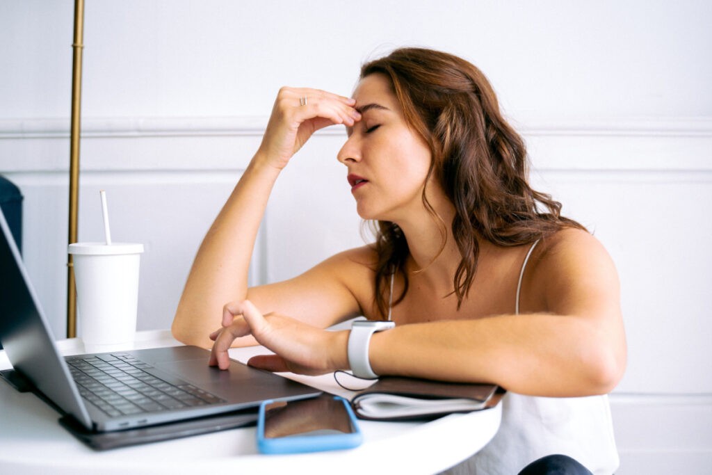 Tired person with laptop at a table, illustrating post-viral fatigue